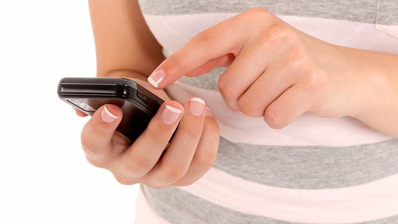 En person håller i en mobiltelefon.