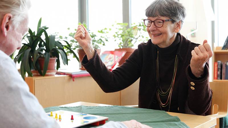 Äldre man och kvinna spelar brädspel.