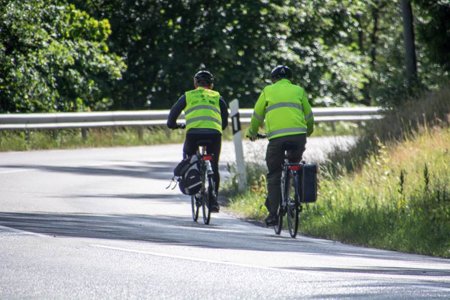 Få din cykel servad medan du jobbar. Två cyklister på en somrig landsväg.