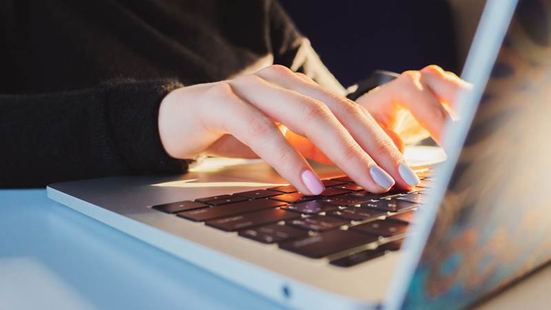 Kvinnohand på laptop