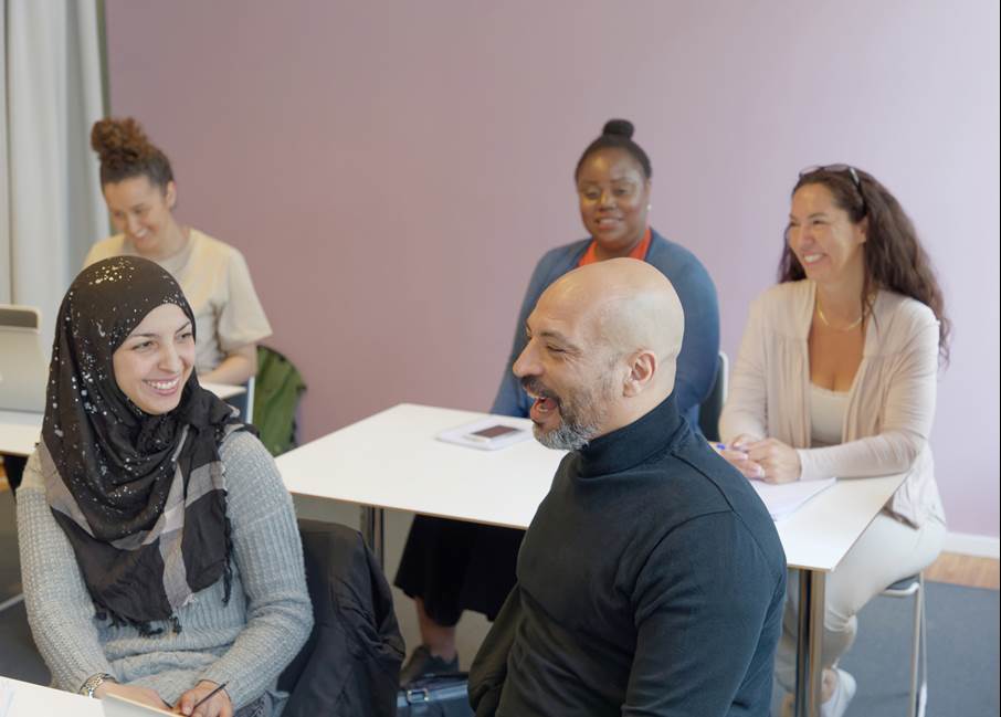 Centrum Vux i Haninge En grupp på fem vuxna studenter sitter i ett klassrum och pratar med varandra.