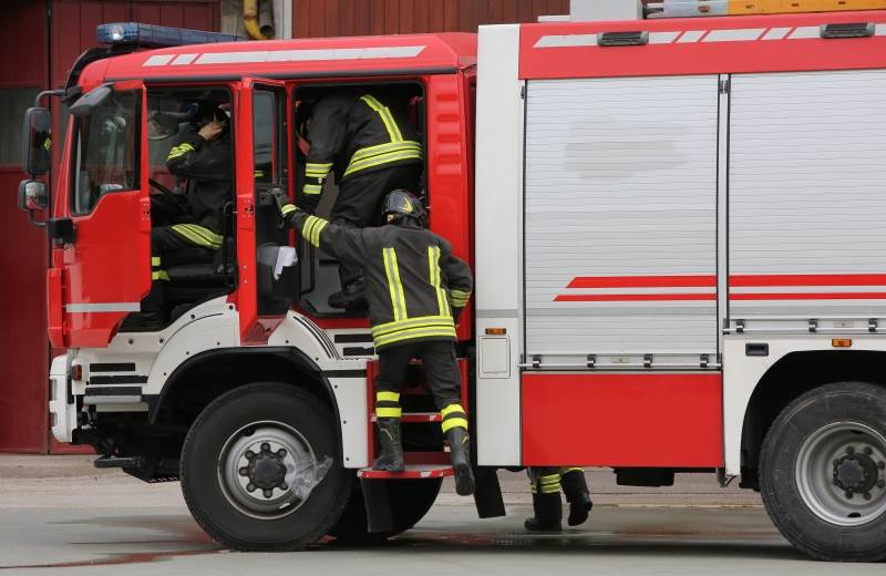 Brandmän kliver in i brandbil.