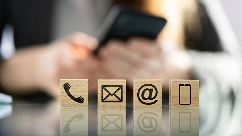 Kvinna med mobiltelefon. Symboler i förgrunden.