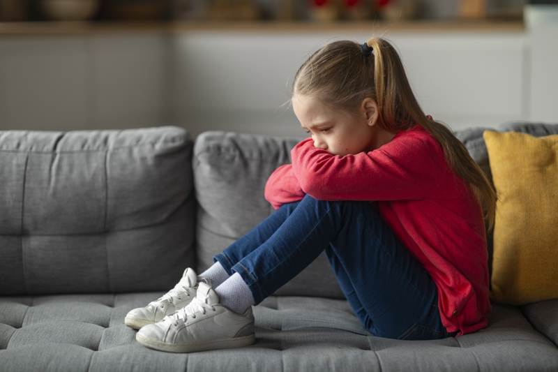 Nu förstärks stödet till familjer som lever med olika slags svårigheter. Flicka som sitter i soffa.