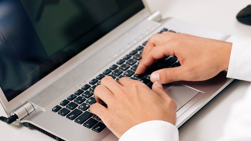 Händer över laptop