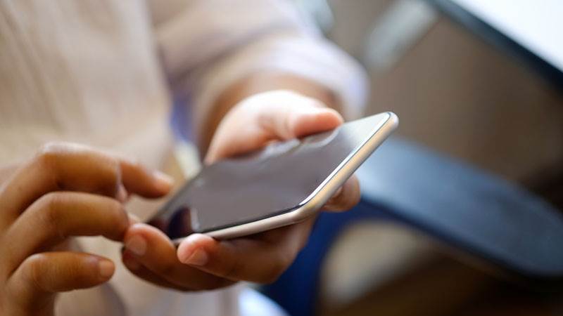 En man som använder en mobiltelefon