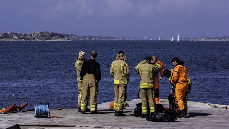 Räddningstjänst förbereder insats i skärgården Sex personer från räddningstjänsten står på en klippa i skärgården och förbereder sig för en insats