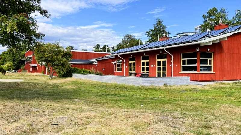 Rudan Center, ett rött trähus med solpaneler på taket
