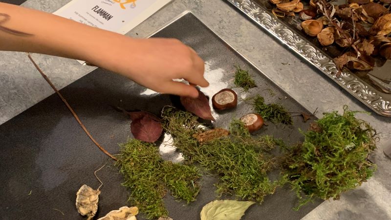 Barn skapar en figur med naturmaterial