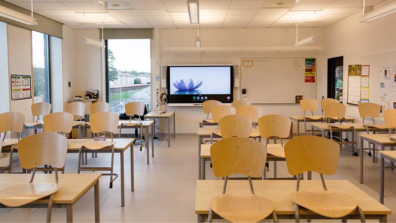 Klassrum i Vikingaskolan, Handen. Stolar står uppställda på bänkarna i ett tomt klassrum.