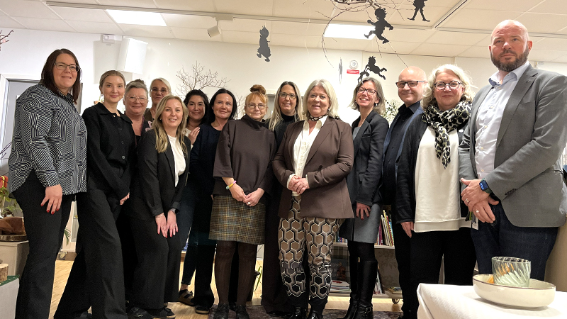 Gruppbild på personer som står i en förskolelokal.