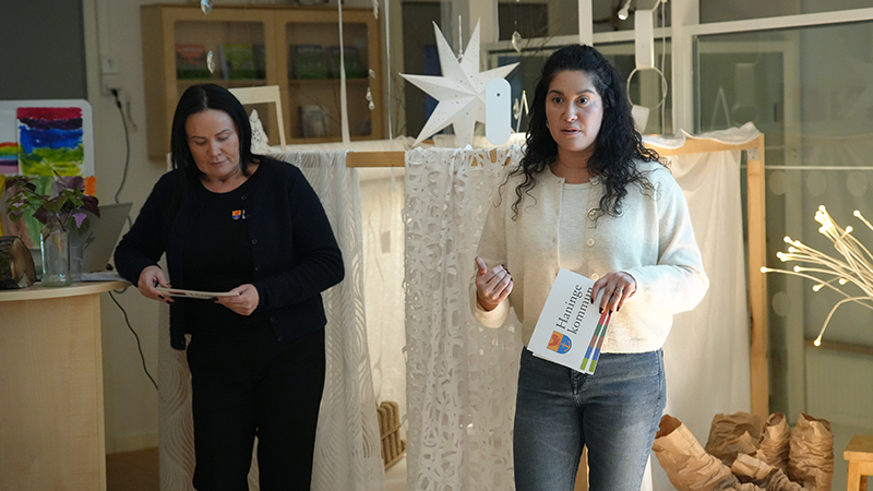 Två kvinnor talar inför publik.