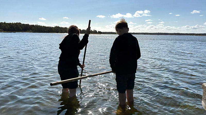Två barn vadar i vattnet