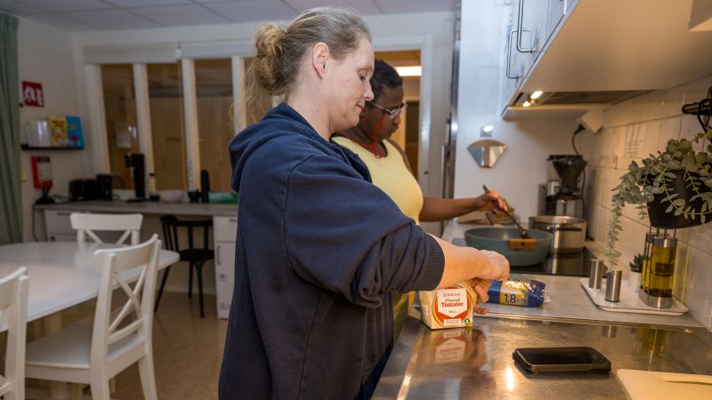 Två personer lagar mat vid spis.