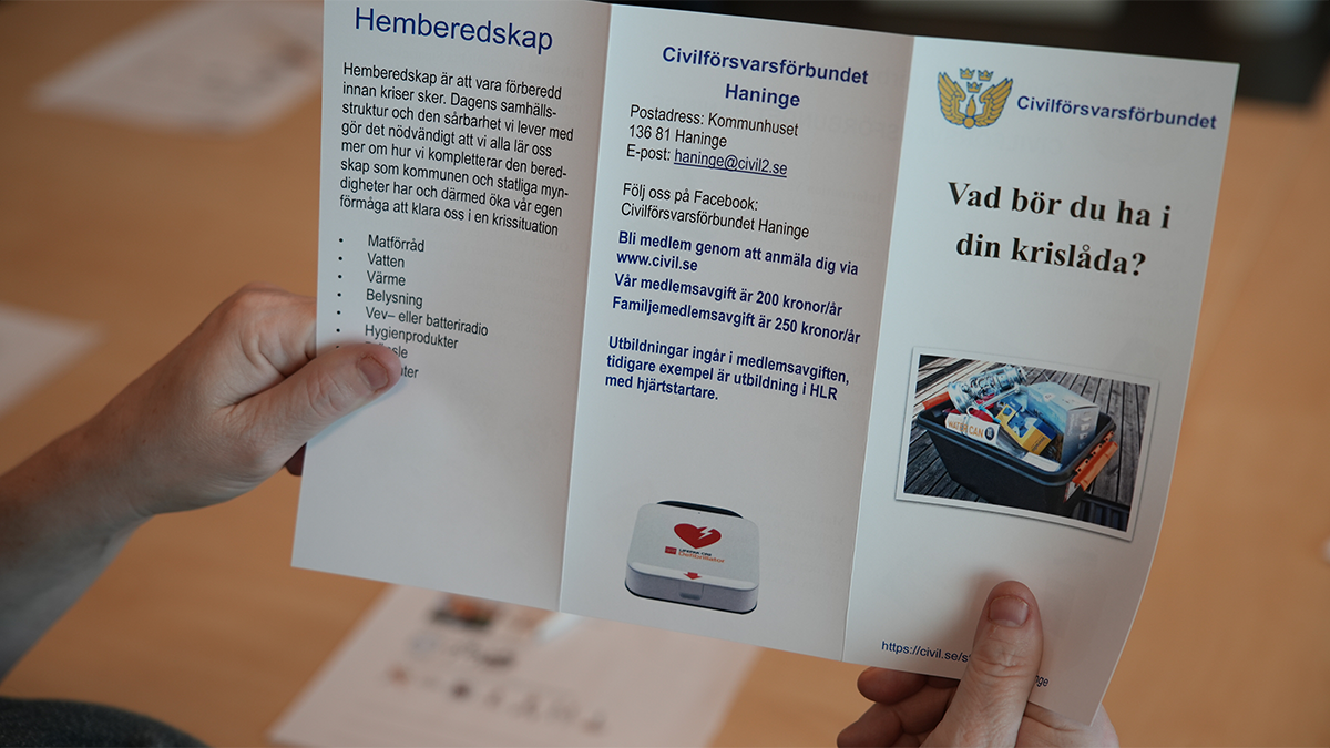 En kvinna håller upp en broschyr framför sig. 