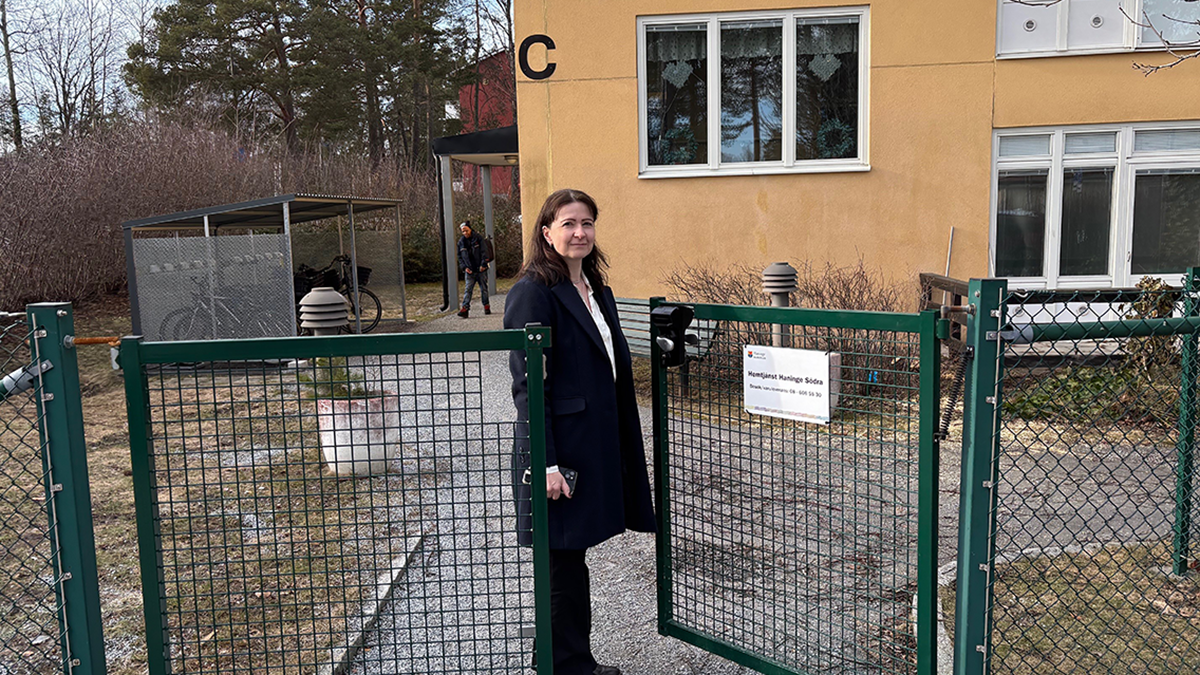 Kvinna utanför orange byggnad.