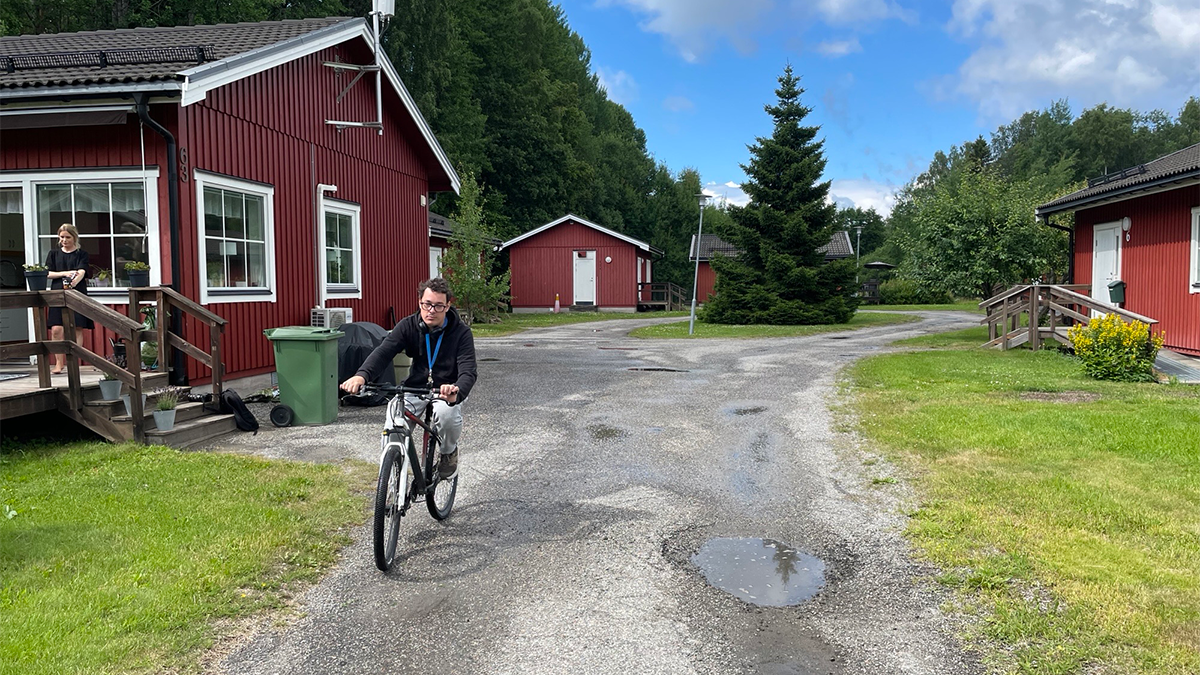 en man cyklar på en grusväg. 