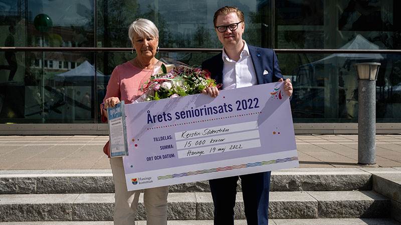 Vinnaren av Årets seniorinsats Kerstin Söderström mottog 15 000 kronor för sina insatser. En kvinna och en man poserar med en stor prischeck