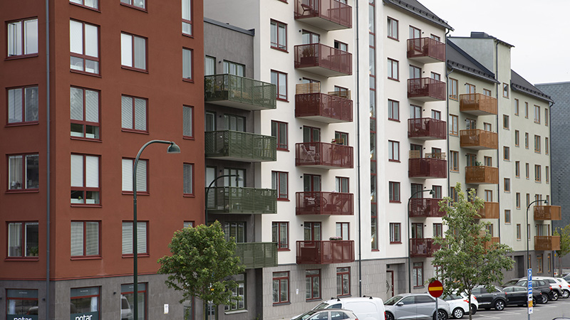 Bostadskvarter med grå, vit och röd fasad