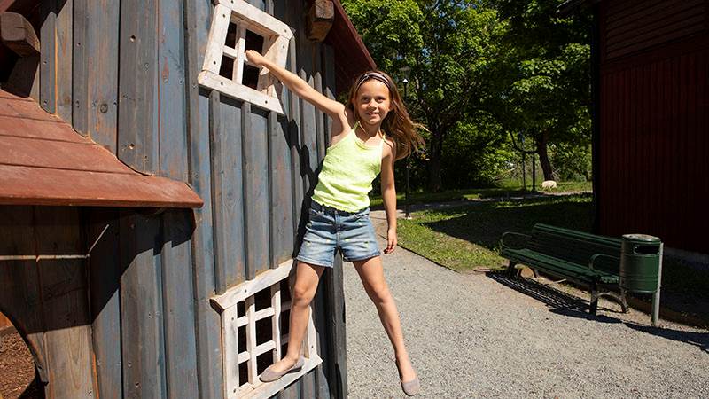 Flicka klättrar på lekplatsen i Tungelsta trädgårdspark