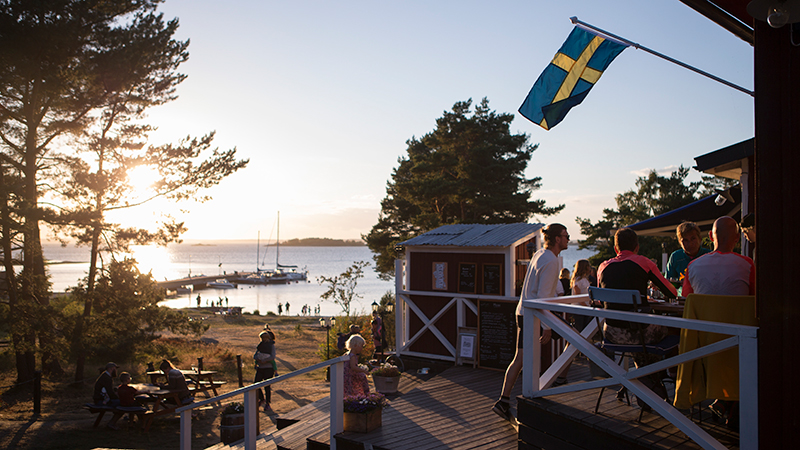 Människor sittandes i solnedgång på Nåttarö krog