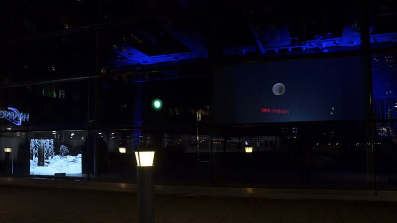 bild på video i Kulturhusets glasfasad och två videoverk som lyser ut mot torget