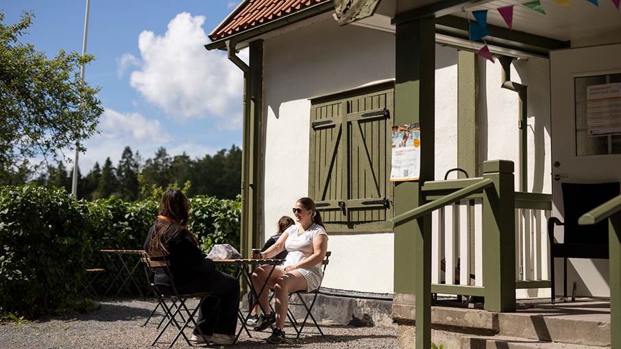 Två personer sitter utomhus i cafémiljö.