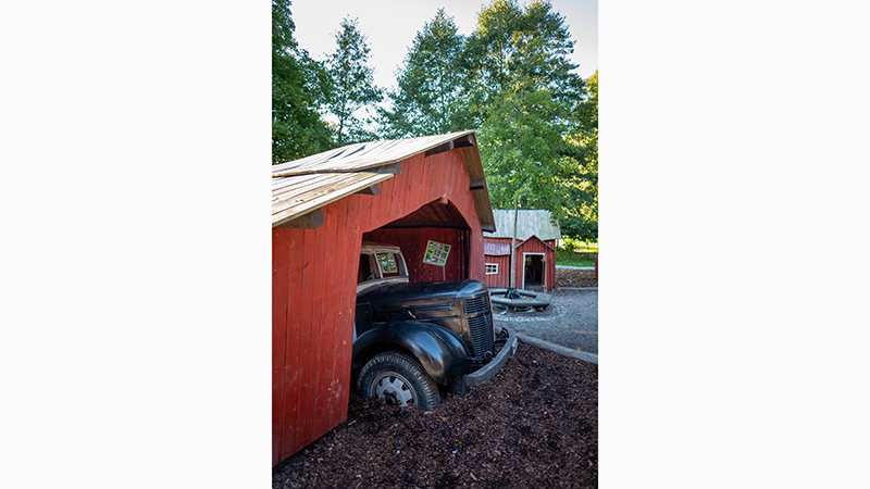 Bil i rött skjul på lekplatsen i Tungelsta trädgårdspark