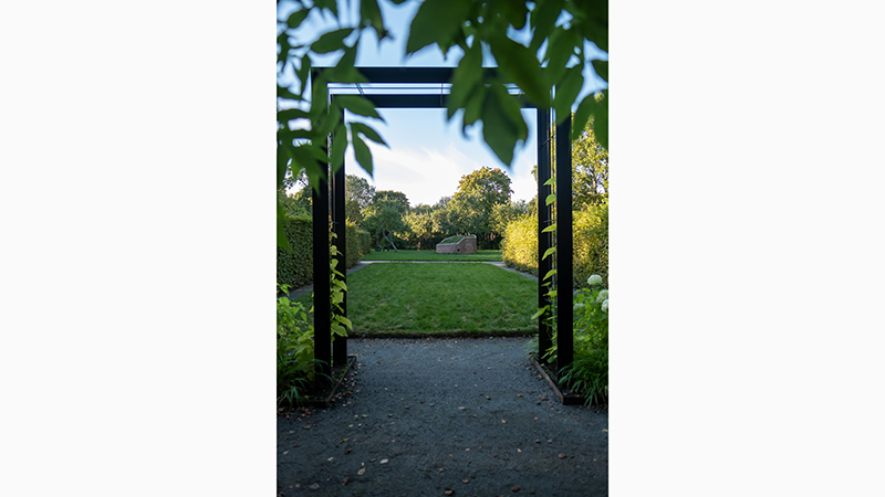 Vy över grönskan och det gamla tornet i Tungelsta trädgårdspark