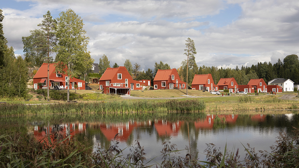 Sex röda trävillor längs en liten sjö