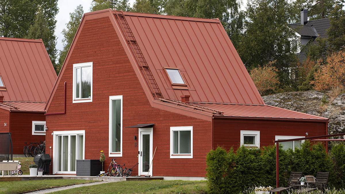 En röd villa i trä med assymetrisk fasad