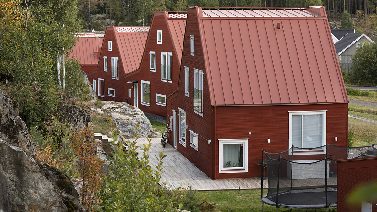 Röda villor i trä med rött plåttak  sedda från sidan