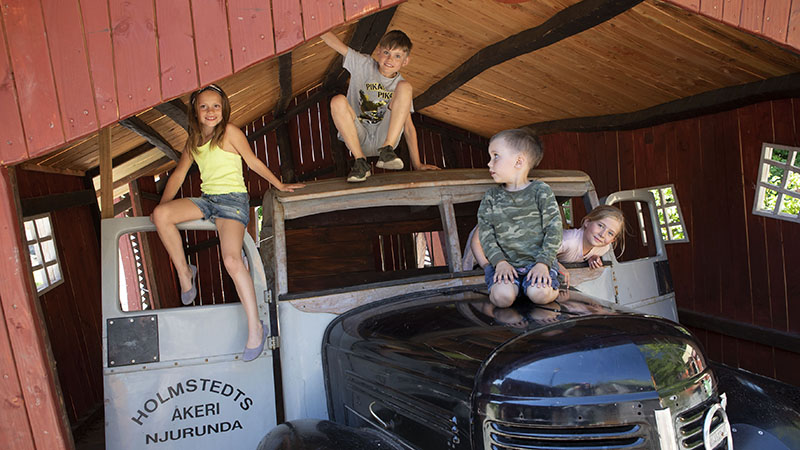 Barn klättrar på bilen i Cykel-Pelles verkstad