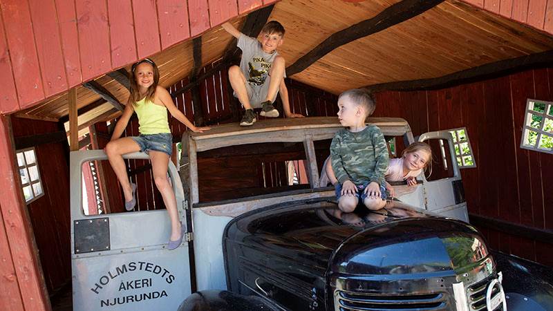 Barn klättrar på bilen i Cykel-Pelles verkstad Barn klättrar på bilen i Cykel-Pelles verkstad