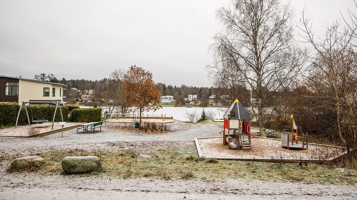 Lekplats med lekhus, gunga, sittplatser med sjöutsikt