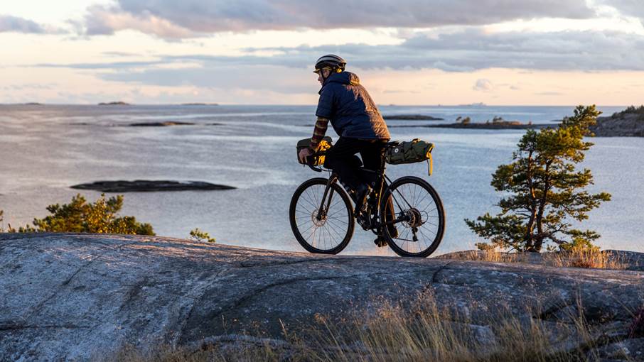 Cyklist vid stenstrand på Utö