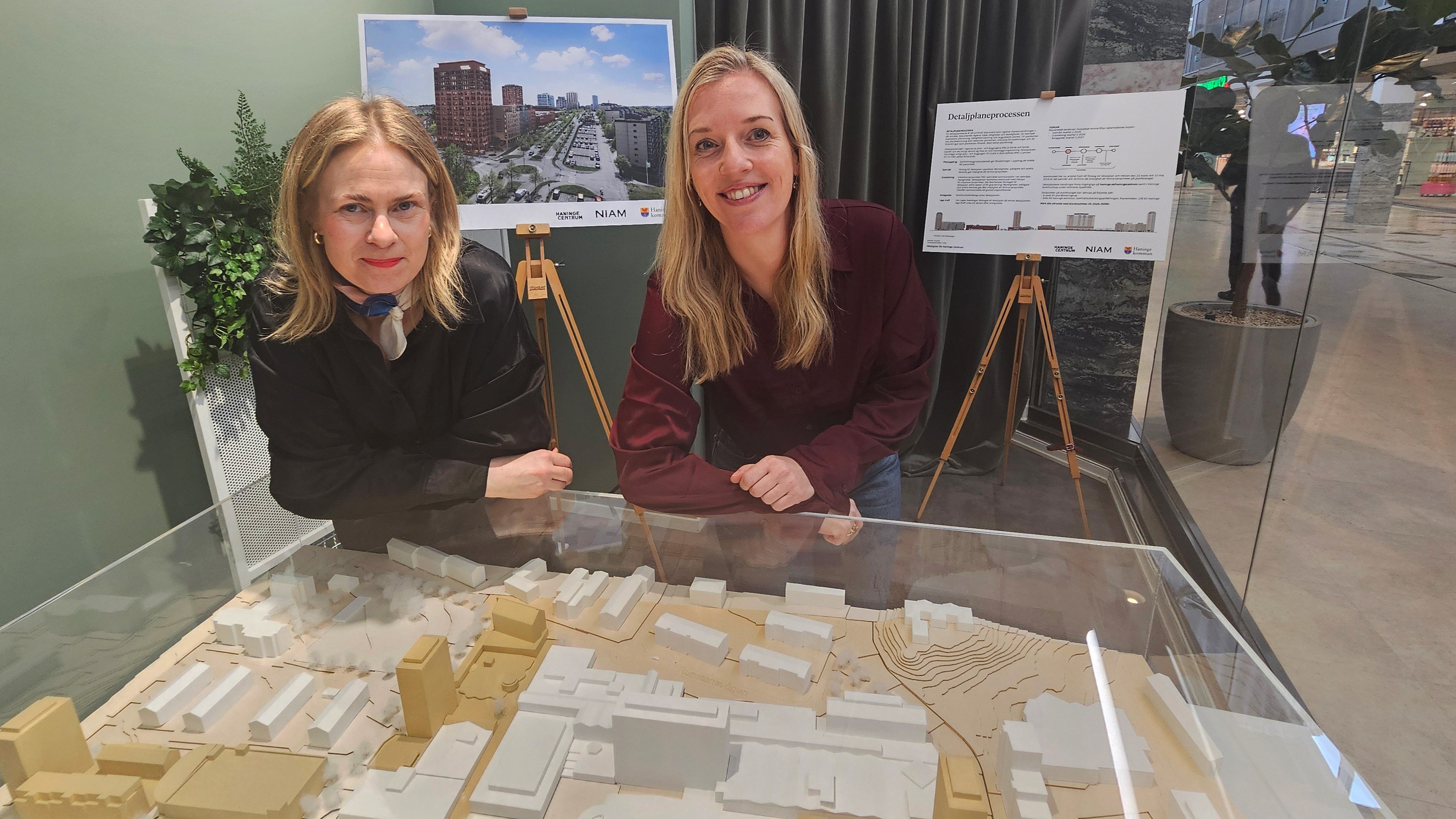 Två personer (kvinnor) framför en tredimensionell modell av hur centrumområdet ska utvecklas. 