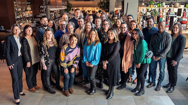 Vinnarna av 2023 års pedagogiska priser. Tjugosju män och kvinnor står uppställda för gruppbild i en restaurangmiljö