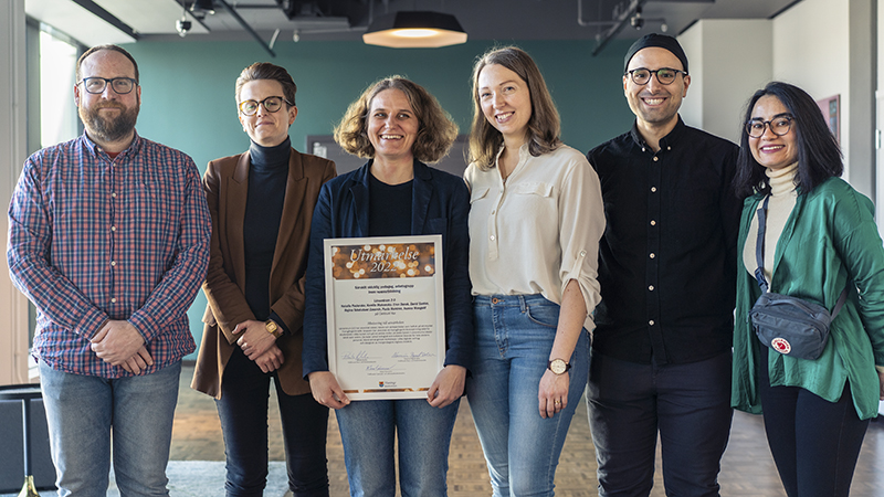 Två män och fyra kvinnor med ett diplom framför sig