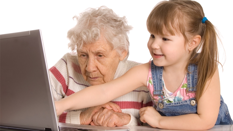 Äldre dam och flicka framför dator