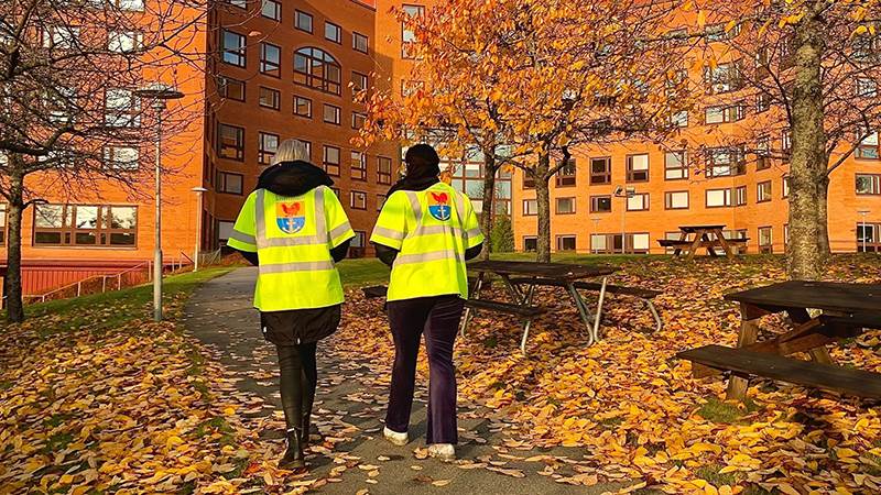Två personer med gula västar utanför kommunhuset