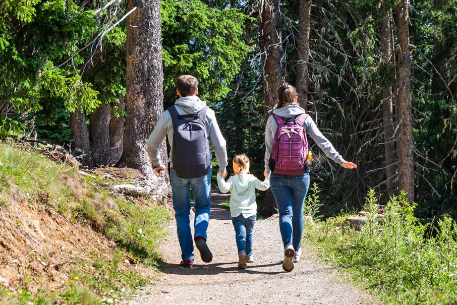 Bild på en familj som springer på en stig i skogen.