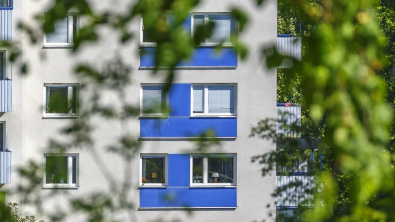 Ett lägenhetshus med blå balkonger