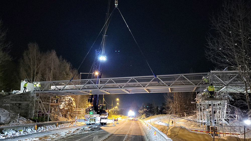 Gångbro lyfts på plats av lyftkran
