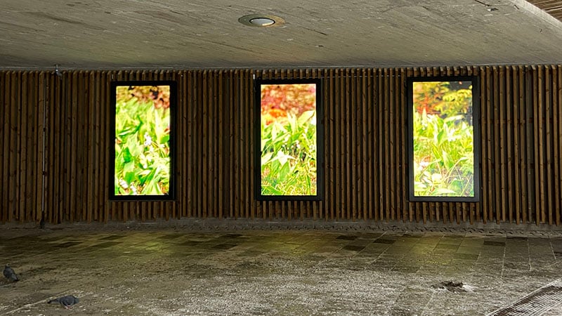 Gångtunnel i träpanel med digitala skärmar