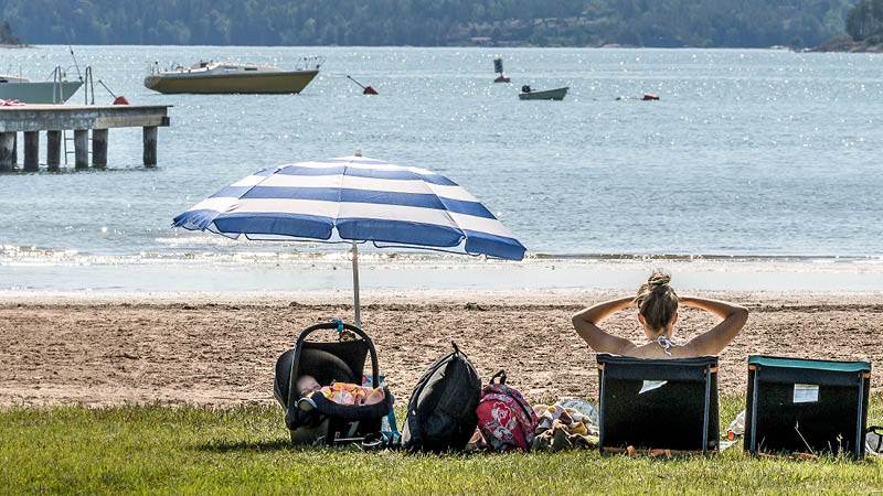 En kvinna som sitter i en solstol och tittar ut över havet vid Östnora havsbad