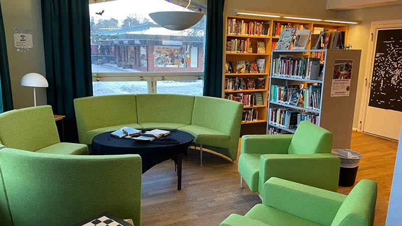En grön soffgrupp på ett bibliotek.