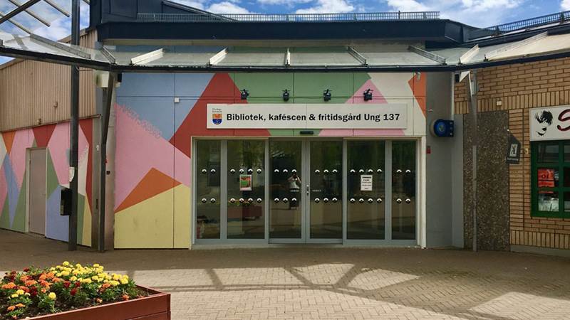 Fasaden på biblioteket i Jordbro, med blå himmel ovanför