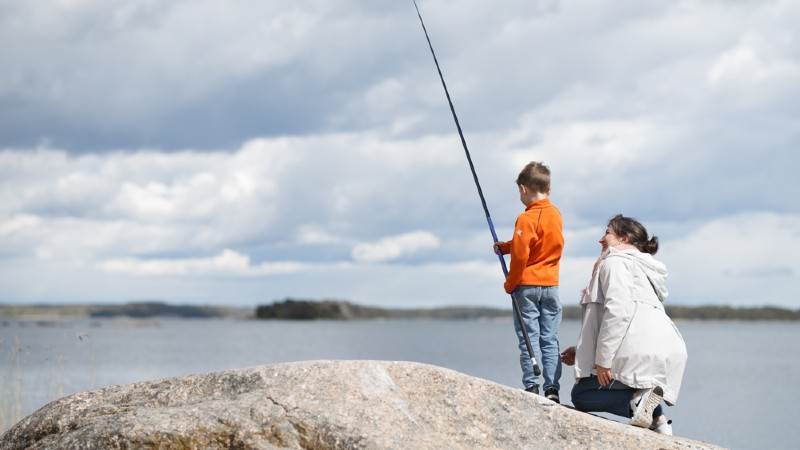 Pojke fiskar med sin mamma