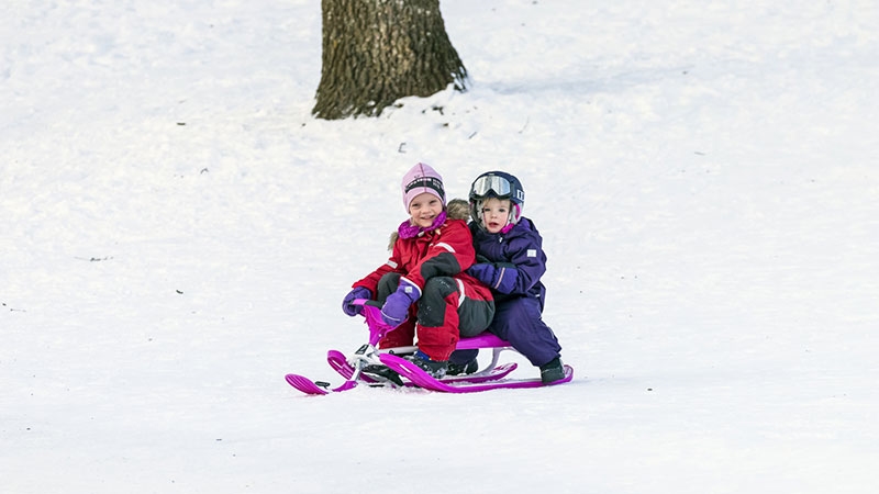 Två tjejer åker snowracer.
